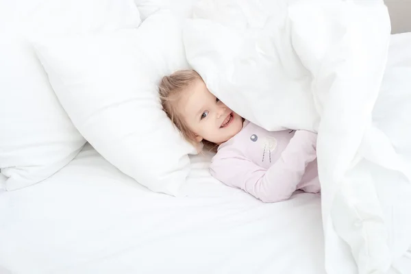 Menina criança na cama macia — Fotografia de Stock