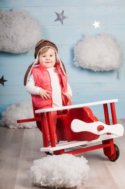 Ahşap oyuncak uçak içinde oturan küçük kız