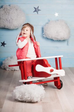 Ahşap oyuncak uçak içinde oturan küçük kız