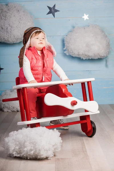 Little girl sitting in wooden toy plane — Stock Photo, Image