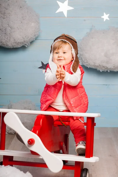 Маленька дівчинка сидить у дерев'яному іграшковому літаку — стокове фото