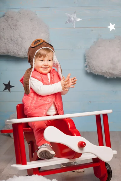 Little girl sitting in wooden toy plane — Stock Photo, Image