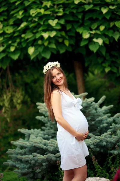 Pareja embarazada feliz y joven en la naturaleza —  Fotos de Stock