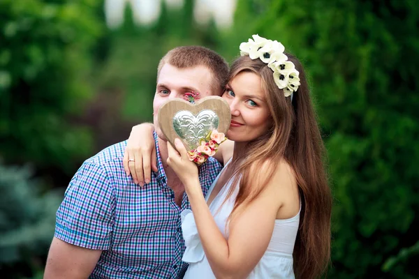 Glad och unga gravida par i naturen — Stockfoto