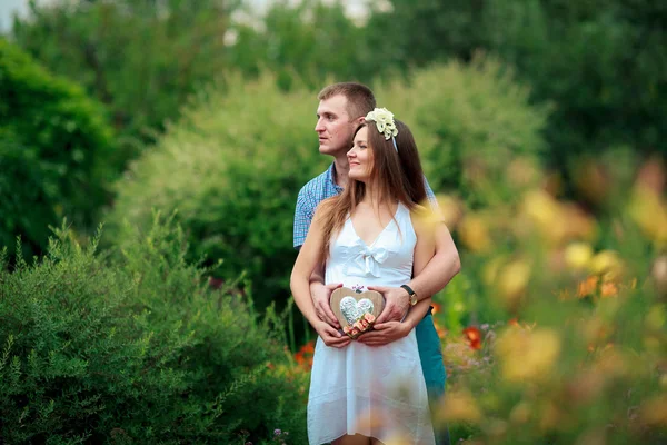 Счастливая и молодая беременная пара в природе — стоковое фото