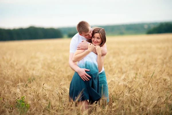 Freiluftporträt eines jungen schwangeren Paares im Feld — Stockfoto