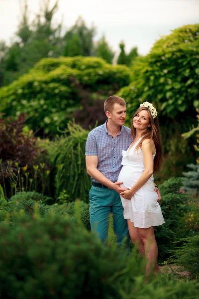 Joyeux et jeune couple enceinte dans la nature — Photo