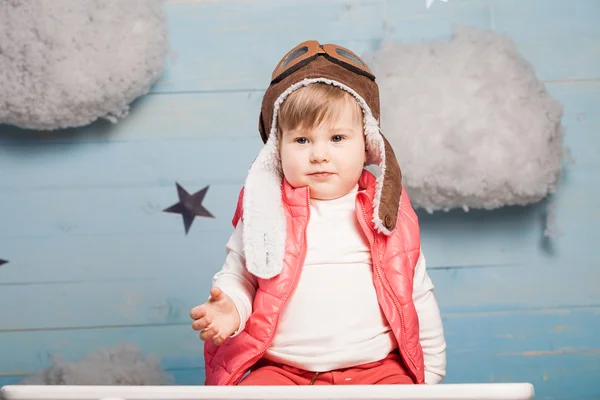 Little girl sitting in wooden toy plane — Stock Photo, Image