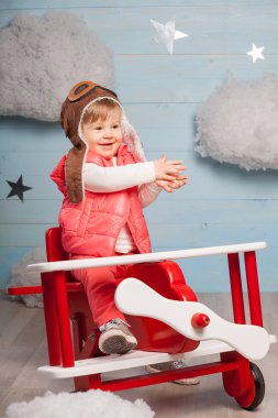 Ahşap oyuncak uçak içinde oturan küçük kız