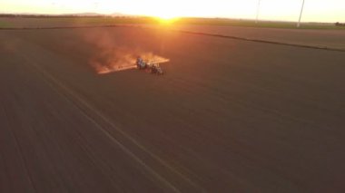   Alan püskürtücü günbatımında yapıyor traktör