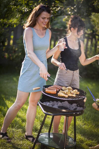 Två vackra flickor att göra mat på grill — Stockfoto
