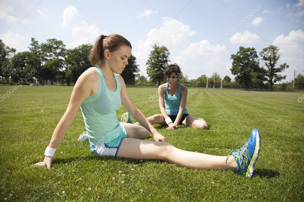 Two young girls stetching before a jogging