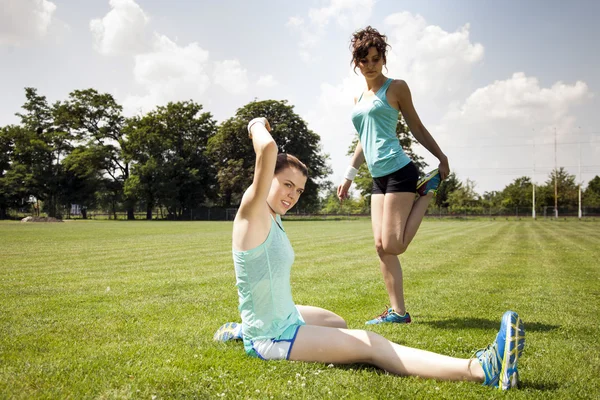 Två unga flickor stetching innan en jogging — Stockfoto