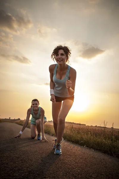 Twee mooie meisjes joggen in de ochtend — Stockfoto