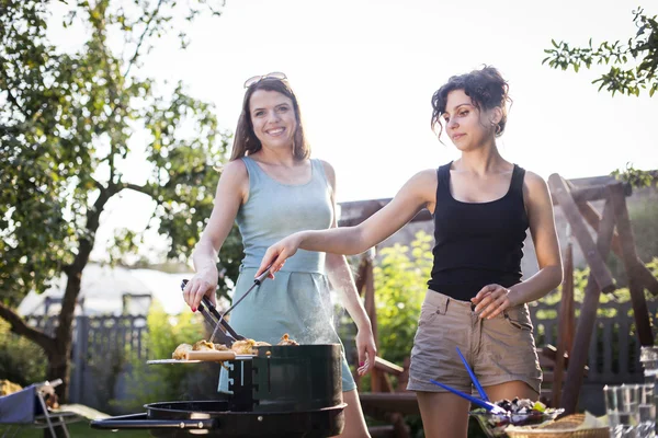 Två vackra flickor att göra mat på grill — Stockfoto