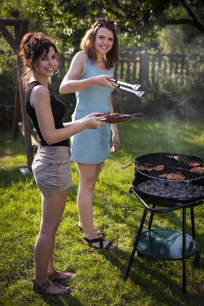 Zwei hübsche Mädchen machen Essen auf dem Grill — Stockfoto