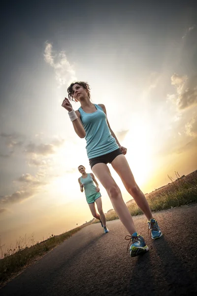 Twee mooie meisjes joggen in de ochtend — Stockfoto