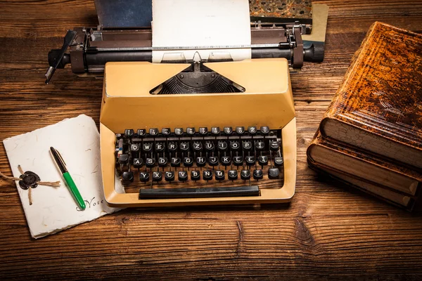 Starý psací stroj, hromadu knih a mnoho kreativity — Stock fotografie