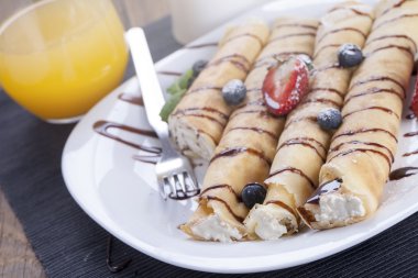 Lezzetli tatlı krep bir tabak taze meyve ile haddelenmiş