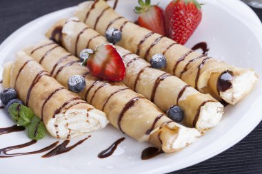 Lezzetli tatlı krep bir tabak taze meyve ile haddelenmiş