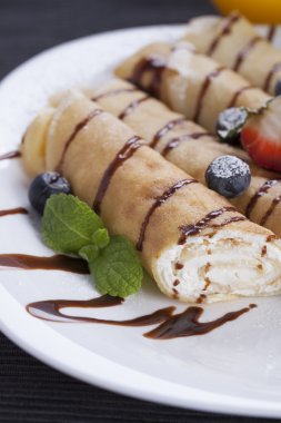 Lezzetli tatlı krep bir tabak taze meyve ile haddelenmiş