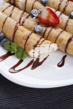 Lezzetli tatlı krep bir tabak taze meyve ile haddelenmiş