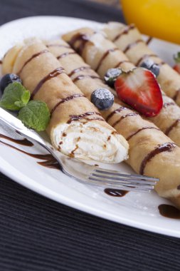 Lezzetli tatlı krep bir tabak taze meyve ile haddelenmiş