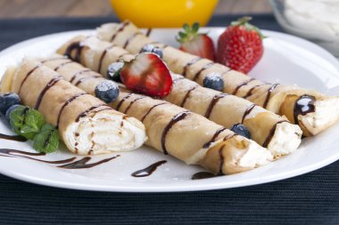 Lezzetli tatlı krep bir tabak taze meyve ile haddelenmiş