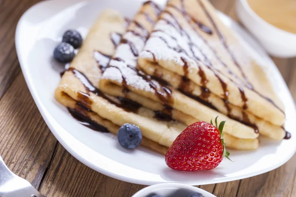 Delicious sweet French pancakes on a plate with fresh fruits — Stock Photo, Image