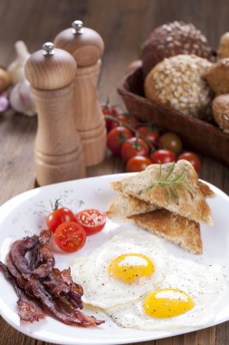 Sahanda yumurta ve domuz pastırması baharat ve sebzeler ile bir plaka üzerinde