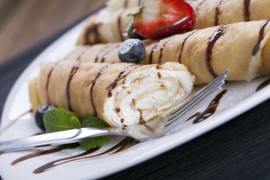 Lezzetli tatlı krep bir tabak taze meyve ile haddelenmiş