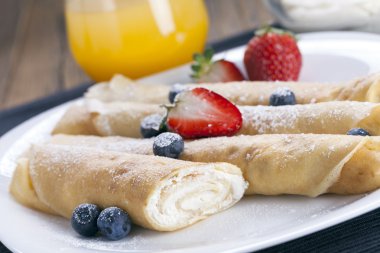 Lezzetli tatlı krep bir tabak taze meyve ile haddelenmiş