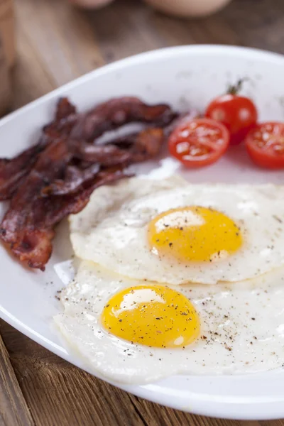 Tükörtojás, bacon, egy tányérra, fűszerek és zöldségek — Stock Fotó