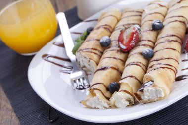 Lezzetli tatlı krep bir tabak taze meyve ile haddelenmiş