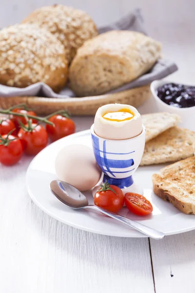 Мягкое варёное яйцо с тостами утром. На заднем плане — стоковое фото