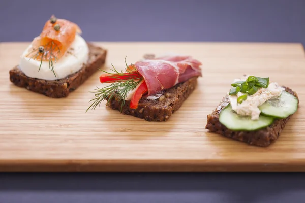 Leckere kleine Sandwiches mit Thunfisch, Käse, Schinken und Fisch — Stockfoto