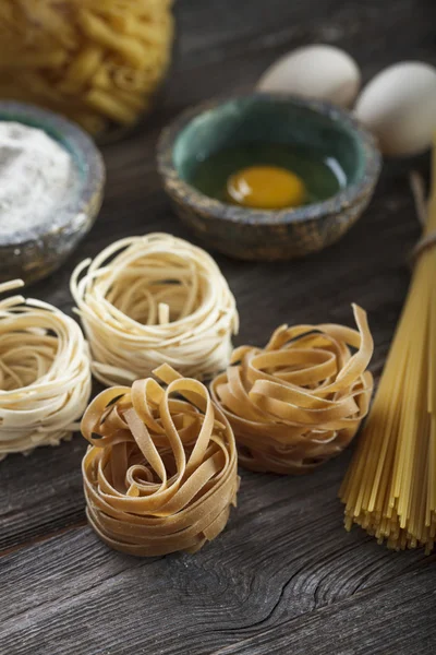 A set of raw pasta and addons on wooden table — Stock Photo, Image