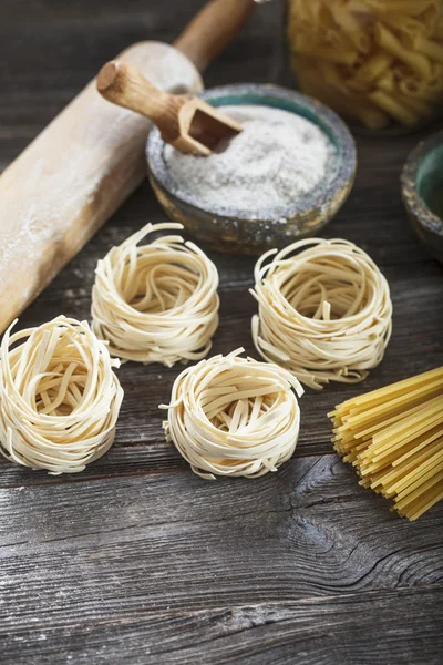 A set of raw pasta and addons on wooden table — Stock Photo, Image