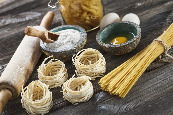 A set of raw pasta and addons on wooden table — Stock Photo, Image