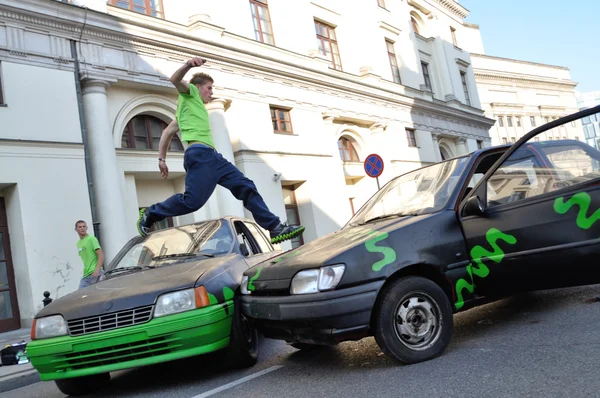Parkour acrobat jumping over the cars