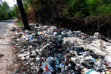 Plastik atıklar ve atıklar yol kenarına bırakılıyor, dikkatsiz ve yanlış yönetimle.