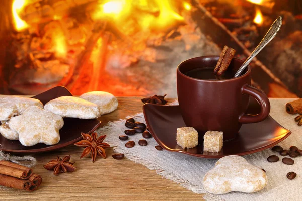 Xícara de café com especiarias no fundo de um firepl ardente — Fotografia de Stock