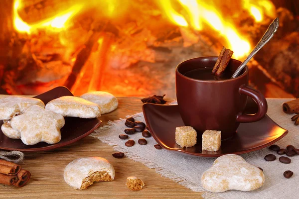 Tasse Kaffee mit Gewürzen im Hintergrund eines brennenden Feuers — Stockfoto