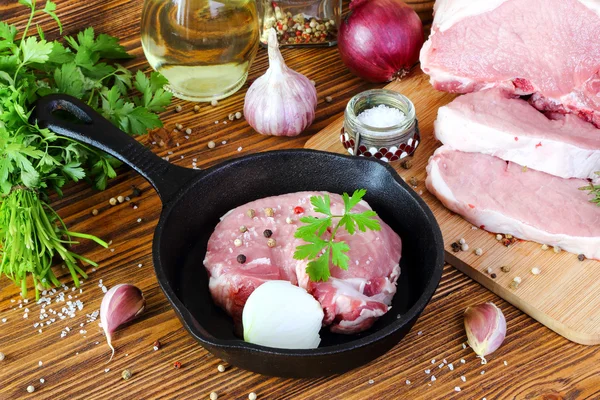 Сырой свиной стейк в сковородке — стоковое фото