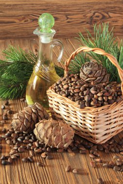 Sedir kozalakları, fındık ve ahşap bir masaya izole sedir fındık yağı