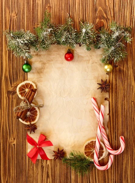 Kerstversiering op de oude vel papier op een houten rug — Stockfoto