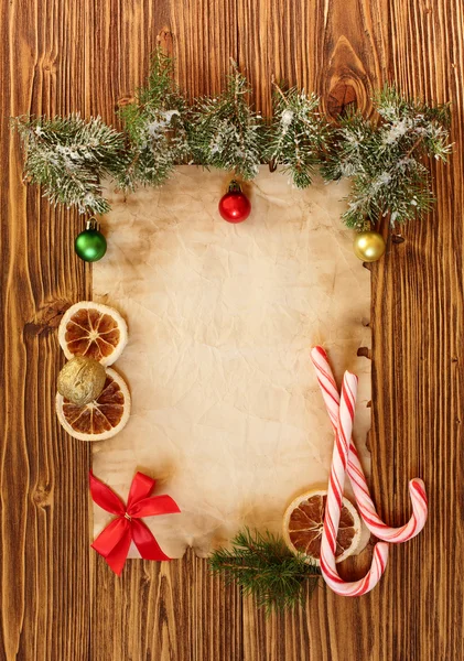 Kerstversiering op de oude vel papier op een houten rug — Stockfoto