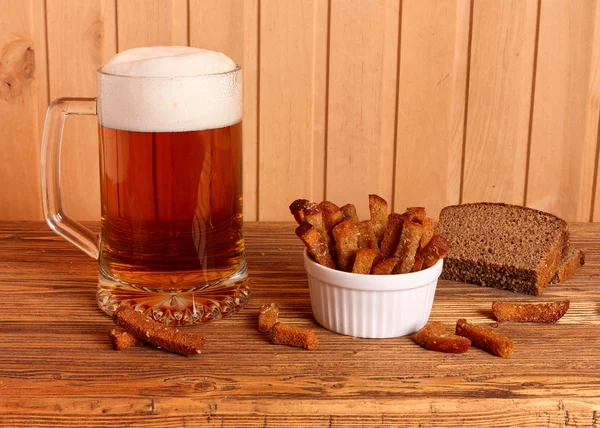 Tazza con birra leggera e cracker salati — Foto Stock