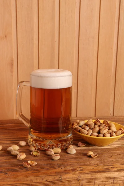 Mug with light beer and pistachios