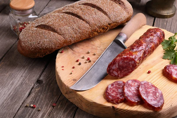 Salami, pain et couteau sur la table — Photo